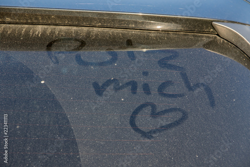 Schmutzige Autoscheibe eines PKW mit Schrift Putz mich