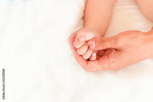 Father holding the hand of his new born son