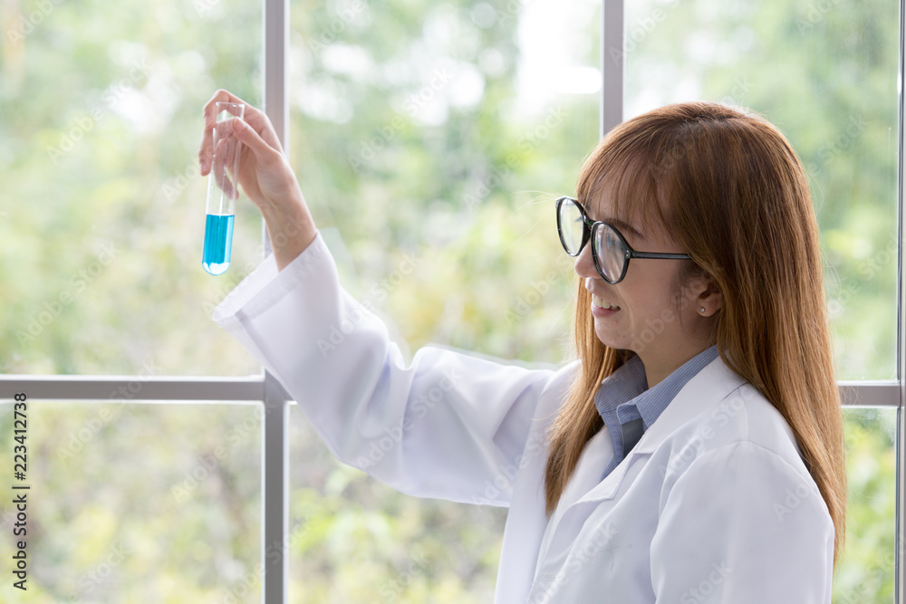 Science whit blue spirit mind. Scientific substance blue in on her hand at lab a background. Beautiful smiling female doctor or Scientist holding Scientific substance organic. asian women. Science whit blue spirit mind. Scientific substance blue in on her hand at lab a background. Beautiful smiling female doctor or Scientist holding Scientific substance organic. asian women.