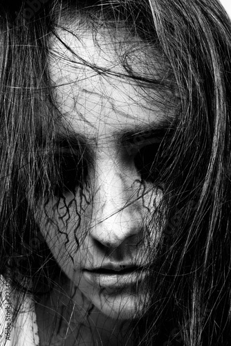 black and white portrait of a girl with black eyes and black veins. madness and obsession with spirits. concept of halloween and day of the dead.