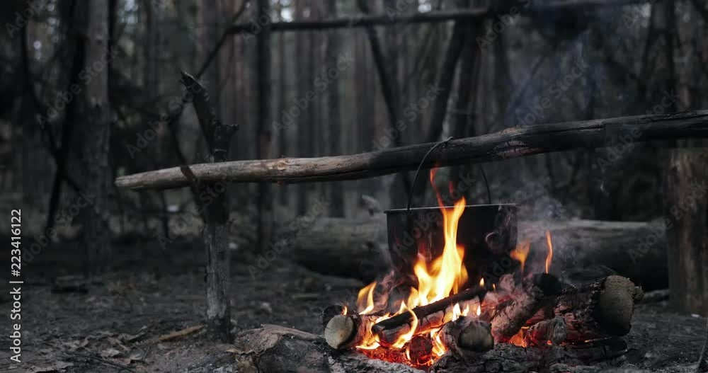Old Retro Camp Saucepan Boiled Water For Soup Preparation On A Fire In Forest. Flame Fire Bonfire At Summer Evening Old Retro Camp Saucepan Boiled Water For Soup Preparation On A Fire In Forest. Flame Fire Bonfire At Summer Evening