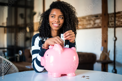Black woman with saving piggy bank