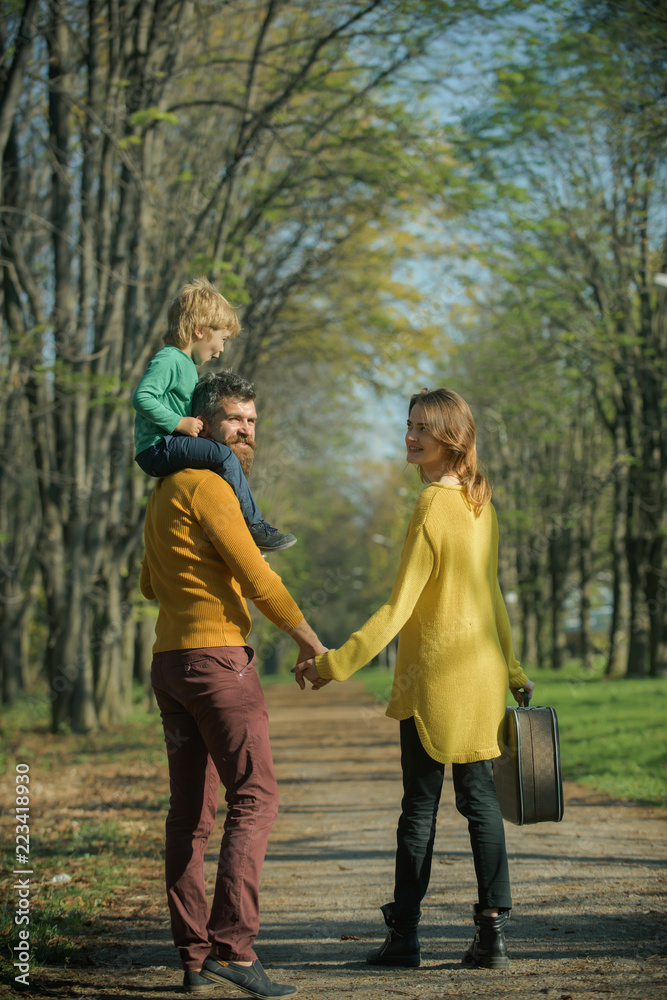 Happy little boy with family go on journey in park. Journey on foot. Where family fun begins Happy little boy with family go on journey in park. Journey on foot. Where family fun begins
