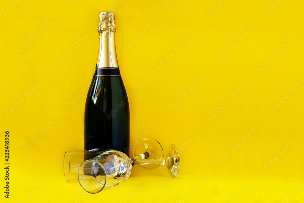 Fototapeta premium Bottle of champagne with yellow background