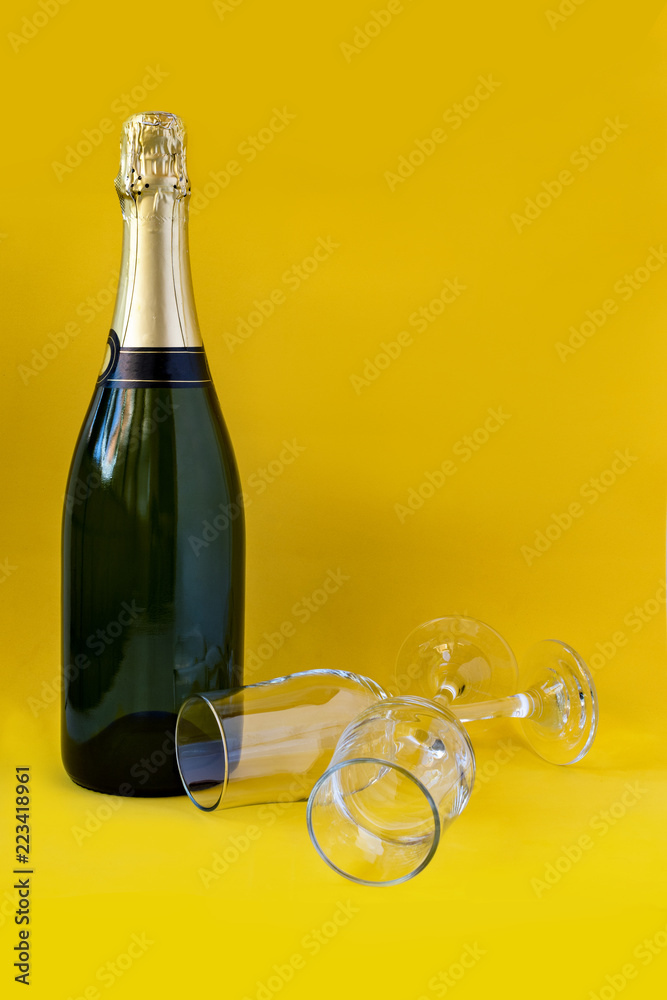 Fototapeta premium Bottle of champagne with yellow background