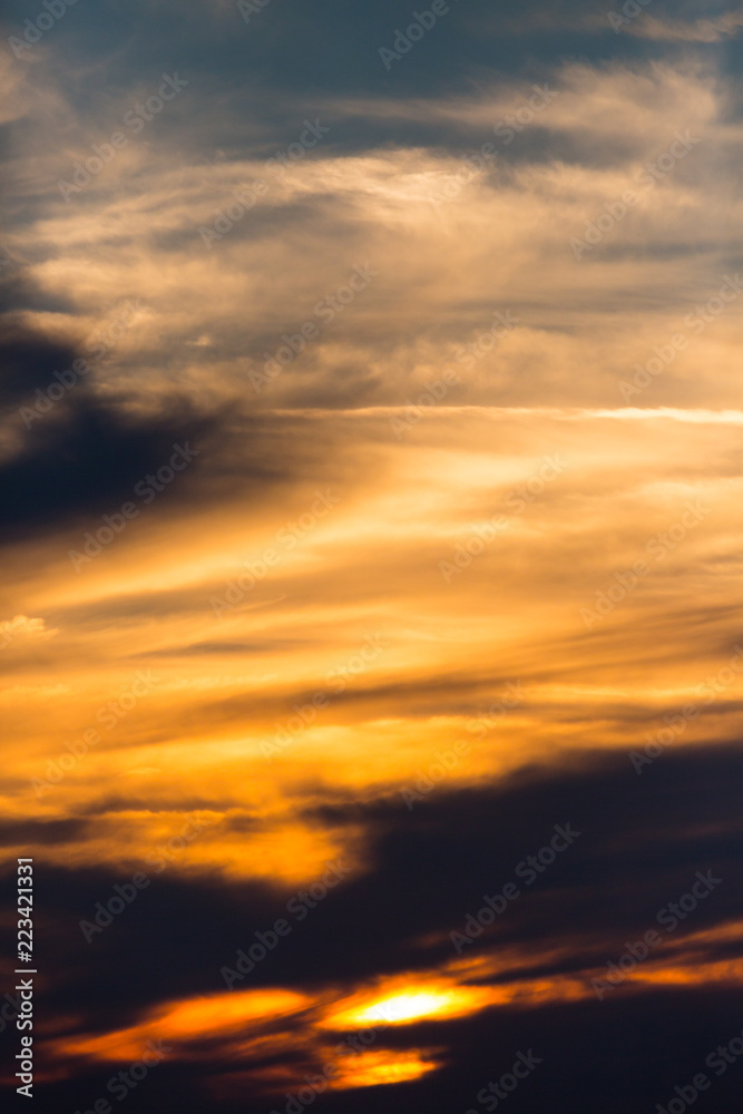 sunset in dramatic orange sky with clouds, blue sky