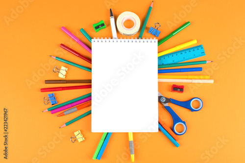 School office supplies on orange background