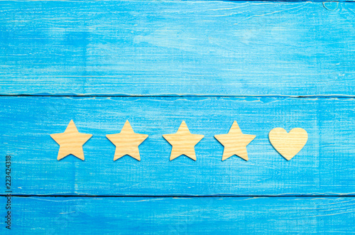 Four stars and a heart on a blue background. Selection of the user and clients. Universal recognition and admiration. Rating of a hotel or restaurant, commercial product or mobile application. photo