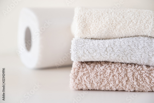 Clean cotton towels and paper towels lye on the table photo