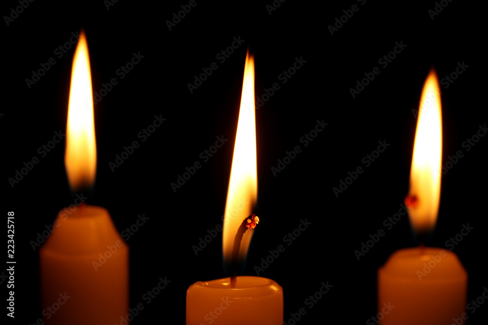 Burning candles on black background Burning candles on black background