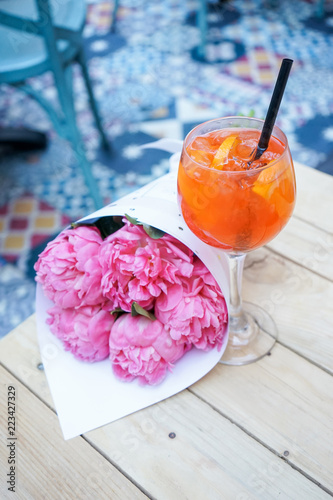 Spritz cocktail. Aperol spritz with beautiful pink peony stylish cafe