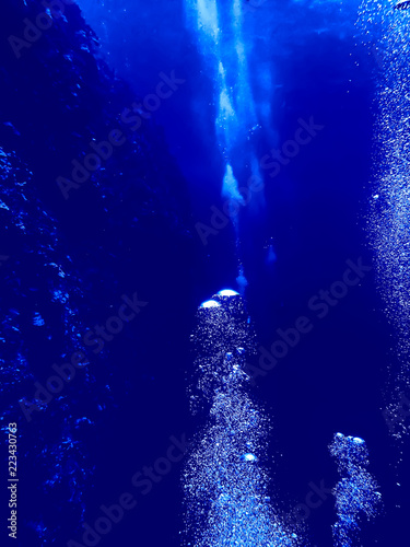 Undersea Wall and Bubbles Made by Divers in Blue