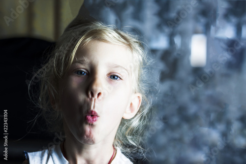 Little blonde Girl whistling. the background is divided into two halves. low cutting depth
