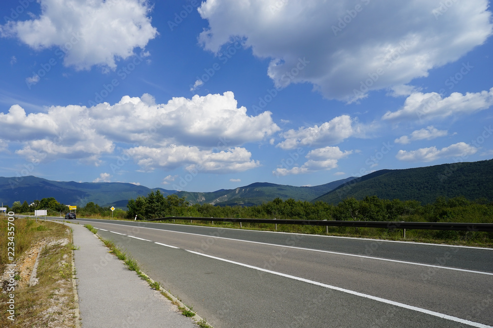 Fototapeta premium Beautiful road landscape view with clouds trees and mountains