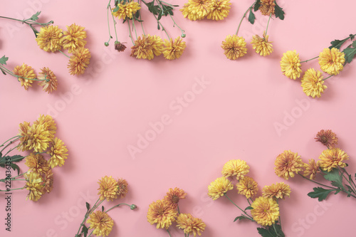 Golden-daisy flowers as border on pastel pink background. Floral pattern. Fall.