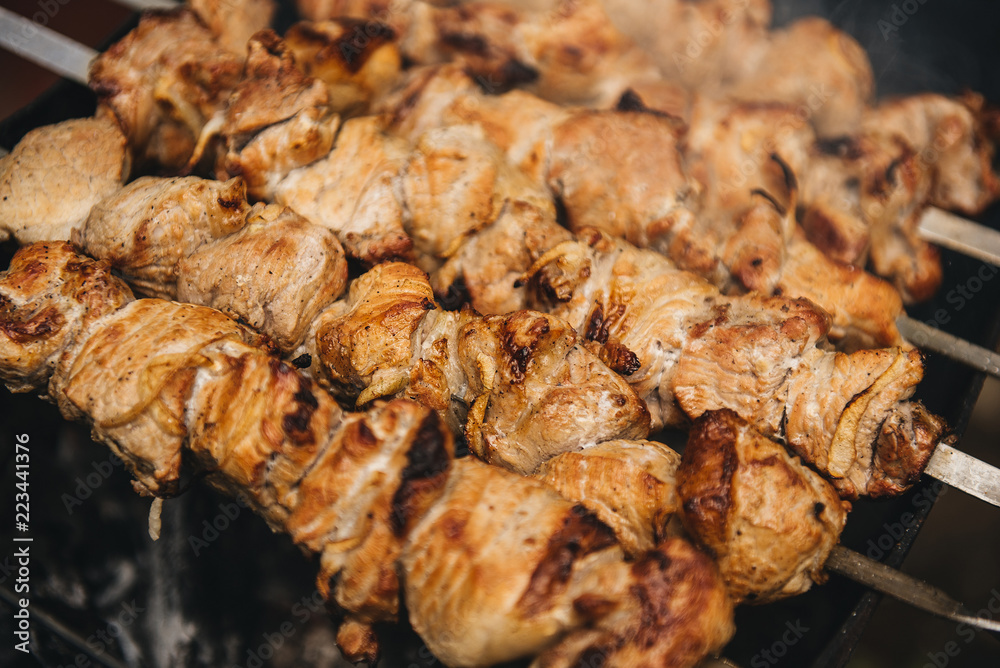 Appetizing shish kebab roasted on skewers on open air charcoal grill. Shish kebab with smoke Appetizing shish kebab roasted on skewers on open air charcoal grill. Shish kebab with smoke