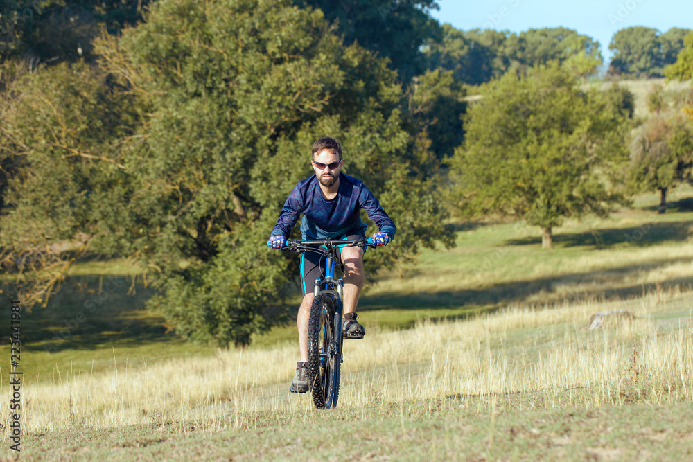 Cyclist in shorts and jersey on a modern carbon hardtail bike with an air suspension fork