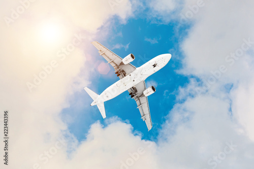 Commercial airplane flying above clouds in divine sun light.