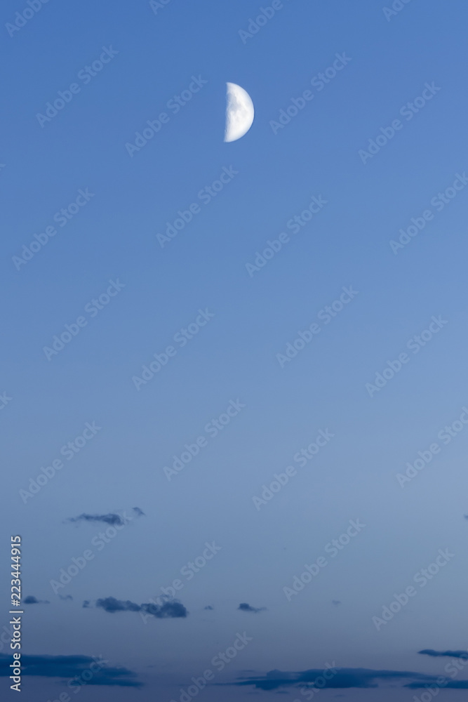 Fototapeta premium half moon against the background of the night blue sky with dark clouds, abstract background