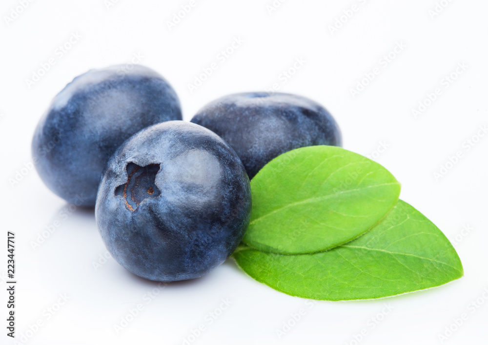 Fresh raw organic blueberries with leaf on white background. Macro close up Fresh raw organic blueberries with leaf on white background. Macro close up