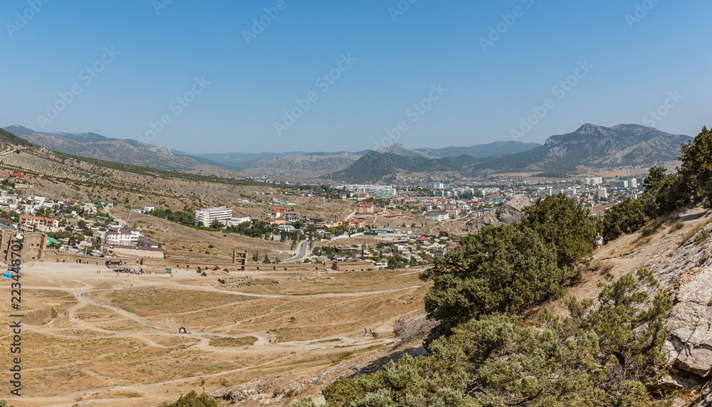 Fototapeta premium Mountain landscape with a city at the foot