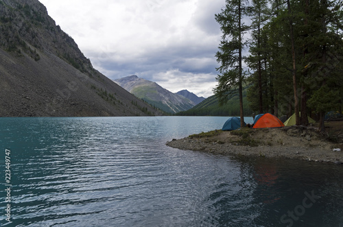 Tourist tents on the shore of a mountain lake. Altai, Russia.