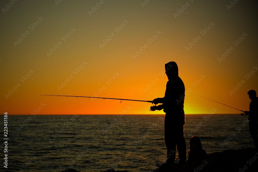 silhouette of fisherman at sunset