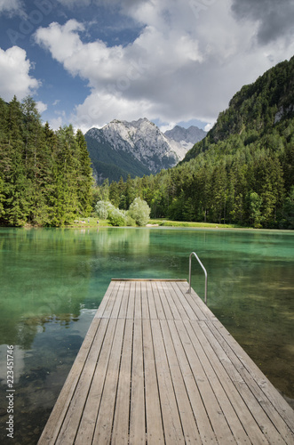 Scenic mountain lake plansarsko view with wooden footbridge, slovenia photo