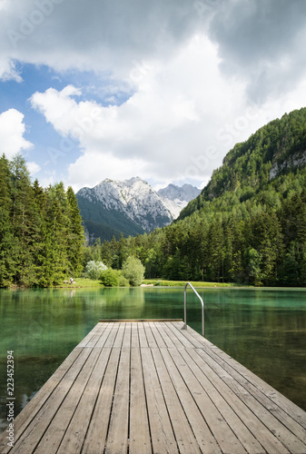 Scenic mountain lake plansarsko view with wooden footbridge, slovenia