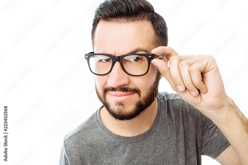 Portrait of brooding bearded man in grey t-shirt looking up and putting hand on face isolated on white background Portrait of brooding bearded man in grey t-shirt looking up and putting hand on face isolated on white background