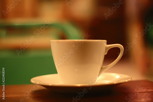close up of white cup of coffee on wooden table