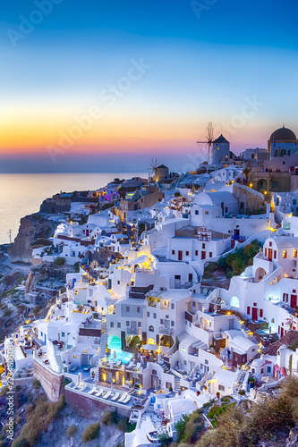 Traveling Concepts. Panoramic View of Famous Old Town of Oia or Ia at Santorini Island in Greece. Taken During Blue Hour with Traditional White Houses and Windmills.