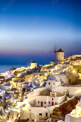 Traveling Concepts and Ideas. Picturesque View of Famous Old Town of Oia or Ia at Santorini Island in Greece. Picture Taken During Blue Hour with Traditional White Houses and Windmills At Dawn