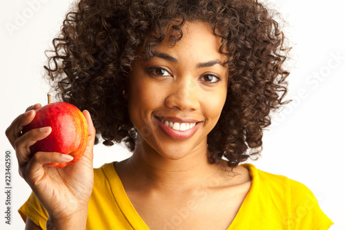 Close up of young African woman smilling and holding apple