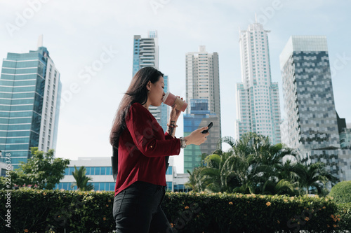 Chinese Woman With Phone Walking And Drinking Coffee