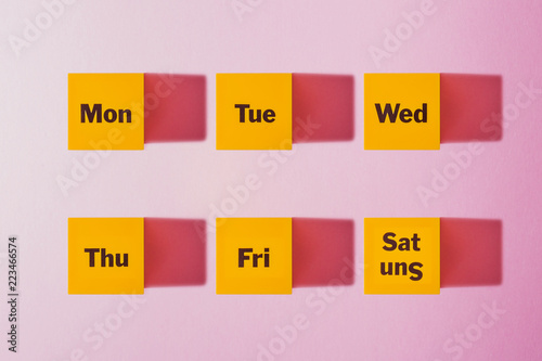 Monday, Tuesday, Wednesday, Thursday, Friday, Saturday, Sunday  a yellow cube Pink background photo