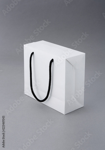 a white paper bag in front of a gray background