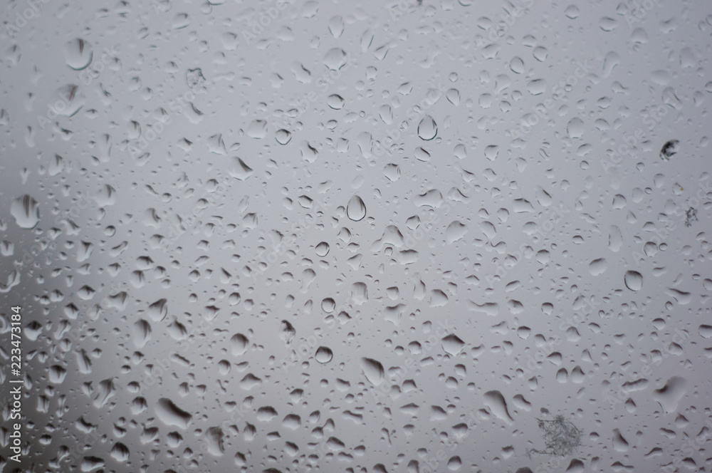 raindrops on window glass on background of cloudy sky raindrops on window glass on background of cloudy sky