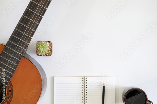 Photography song writer table a workspace with musician acoustic guitar and coffee cup with notepad paper on top view desk