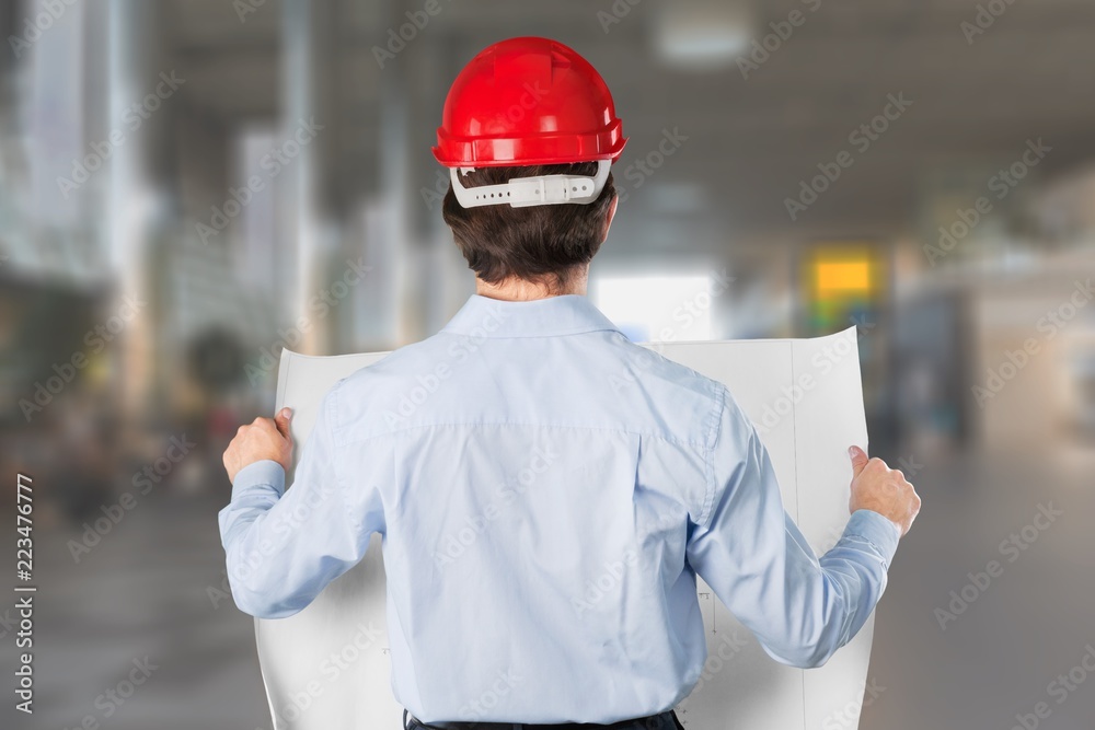Young business man in red helmet on signs background Young business man in red helmet on signs background