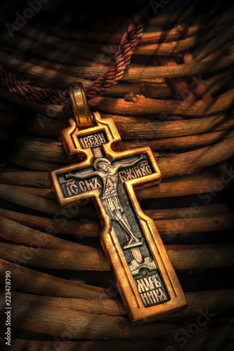 Foto the orthodox cross lies on wooden rods of a willow
