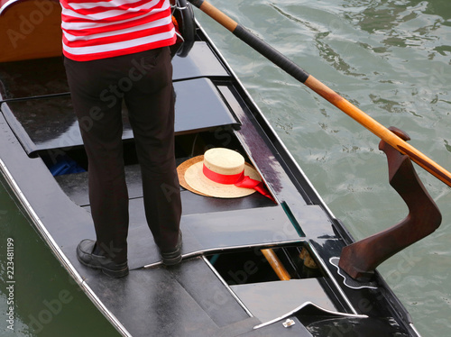 Gondolier on the gondola and his boater in Venice photo