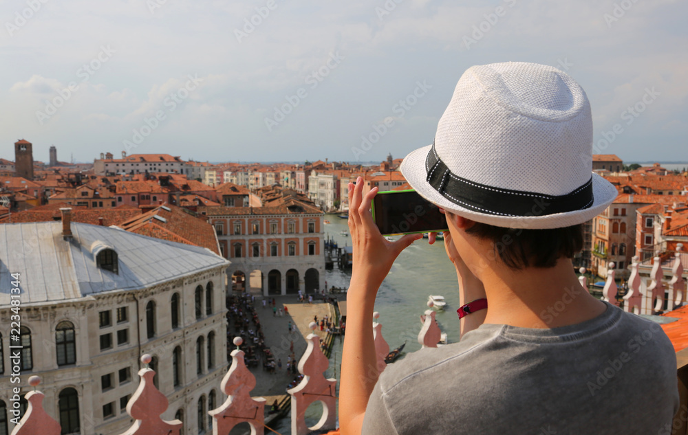 photographer with his smart phone takes pictures of grand canal