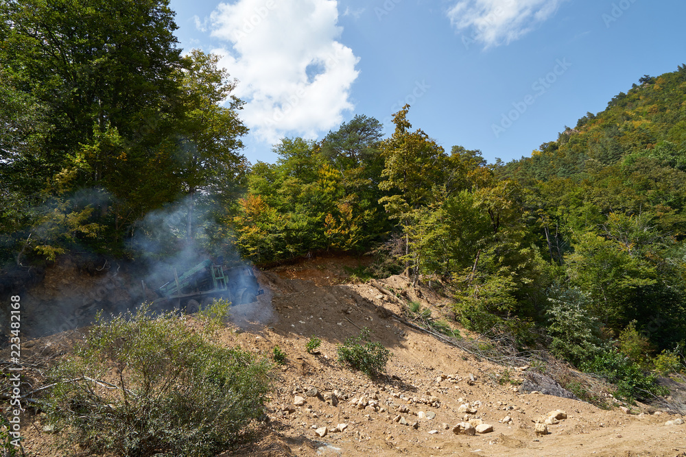 A log truck is driving along a mountain road. A log truck is driving along a mountain road.