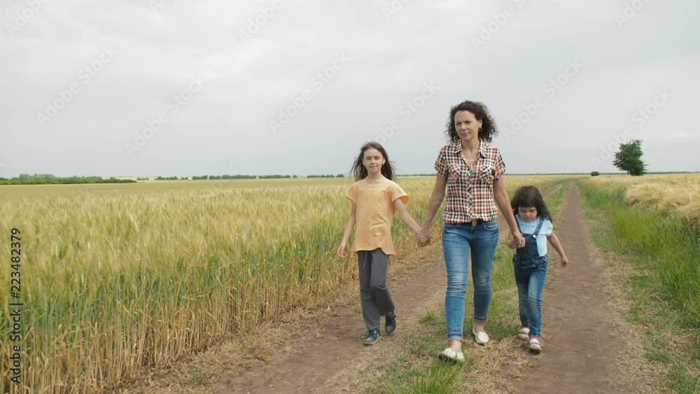 A woman is walking with children. Children with mom walk in nature. A woman is walking with children. Children with mom walk in nature.