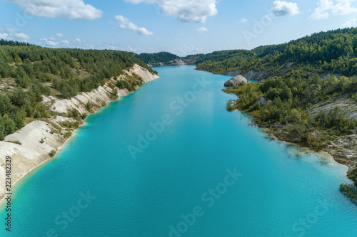 Very beautiful abandoned mountain quarry. The mine workings are filled with water of a deep blue color. Aerial view