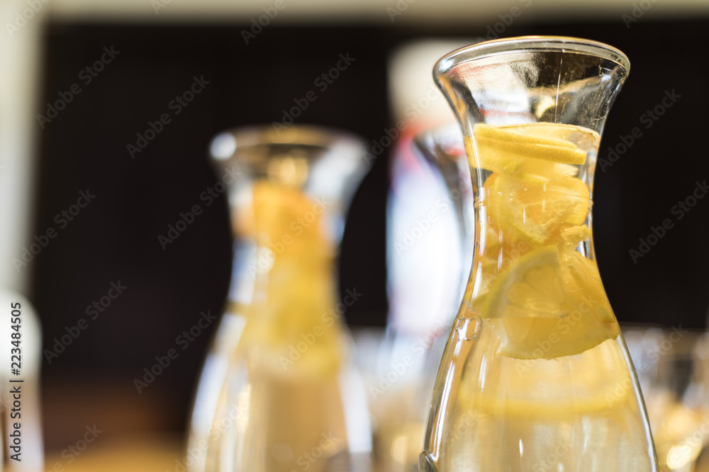 A glass pitcher with water and lemons A glass pitcher with water and lemons