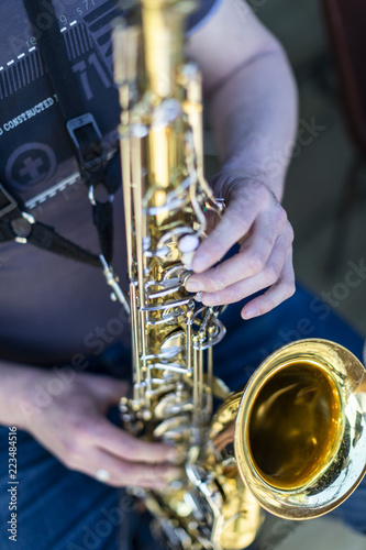 A person playing a lacquered saxophone
