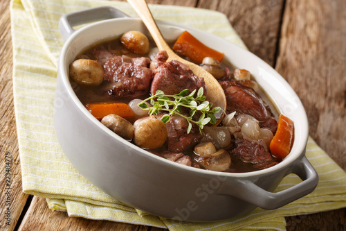 Traditional recipe of French cuisine Coq au vin close-up in a pot. horizontal