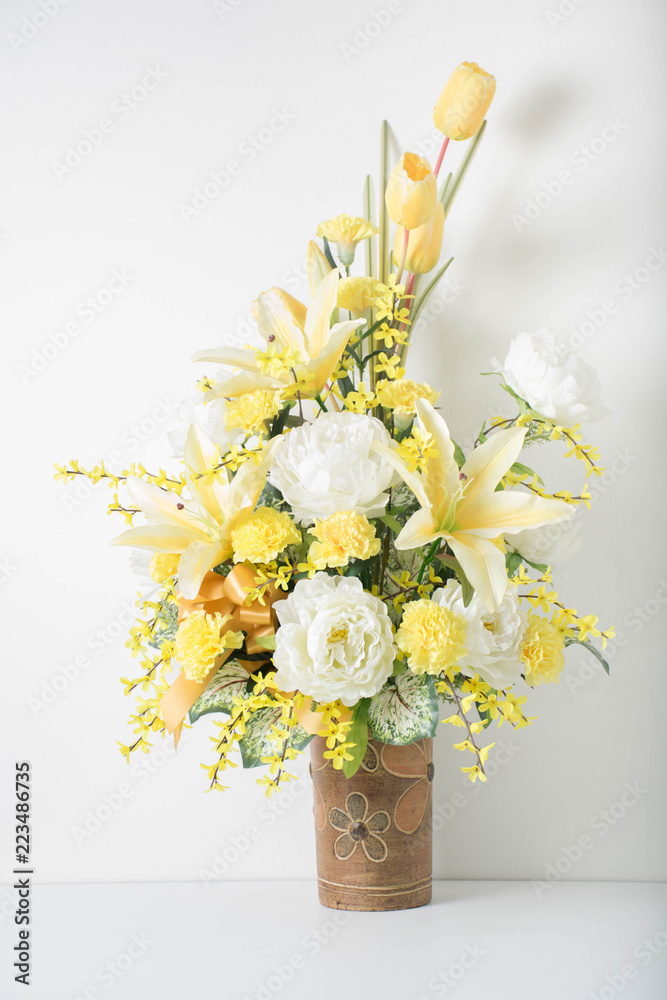 closeup beautiful yellow and white flowers bouquet on pottery vase,white background,copy space